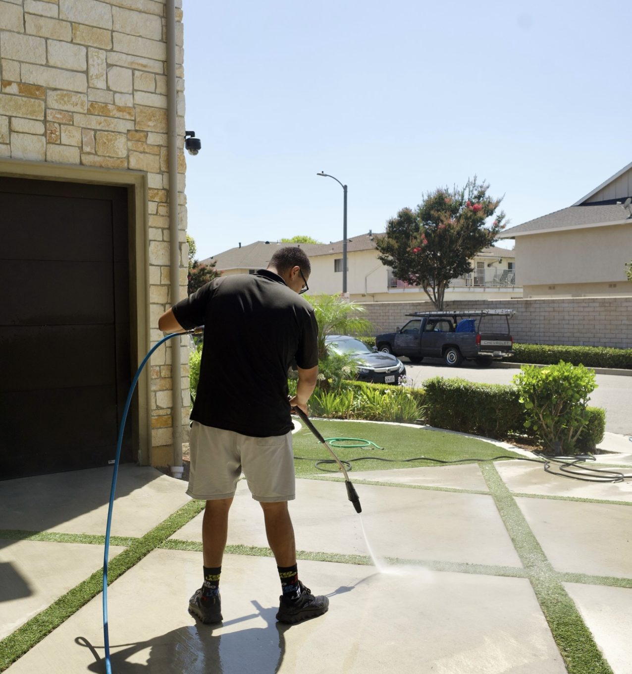 Pressure washing a driveway and walkway outside a home
